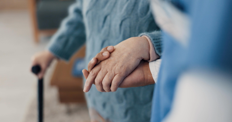 An Aspire Healthcare professional holding hands with a patient at one of our Skilled nursing facility.