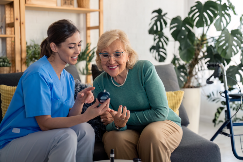 A nurse from Aspire teaching a patient how to use their blood sugar monitor.