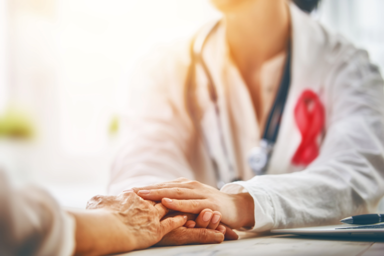 A doctor holding a patient's hand as they go over the oncology services offered by Aspire.